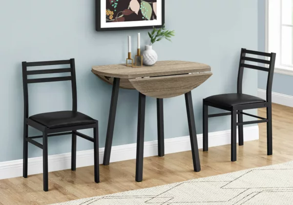 A three-piece dining room set includes a round table with two drop leaves supported by sliding support bars, an angled table leg, and a strong tabletop with a dark taupe wood-look finish. 2 dining chairs with ladder backs and no arms, black metal frames, and padded, leather-like fabric seats. From Monarch Furniture, MO-I-1003 from Homebay Furniture.